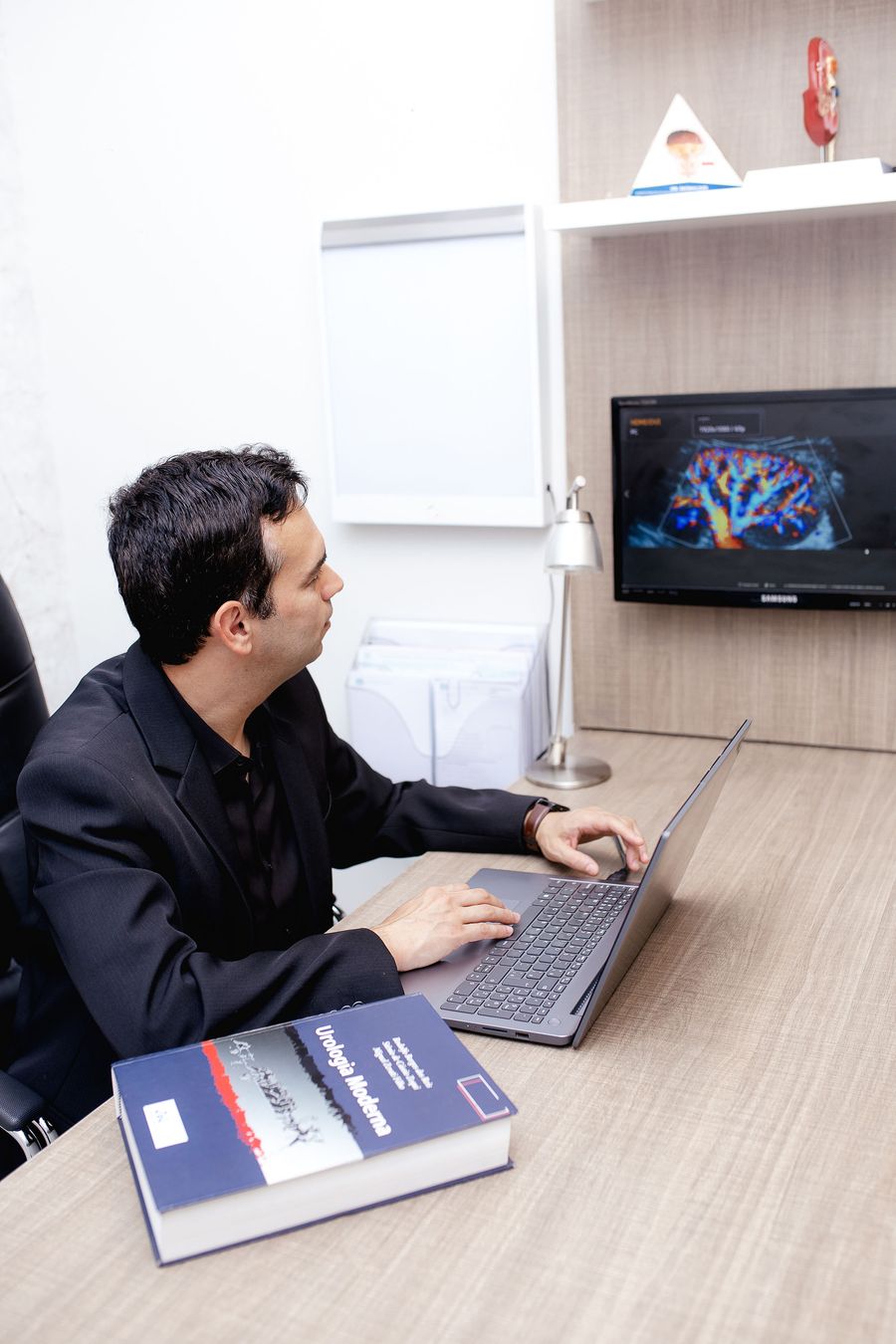 Dr. Renato Sola analisando exame de imagem durante a consulta